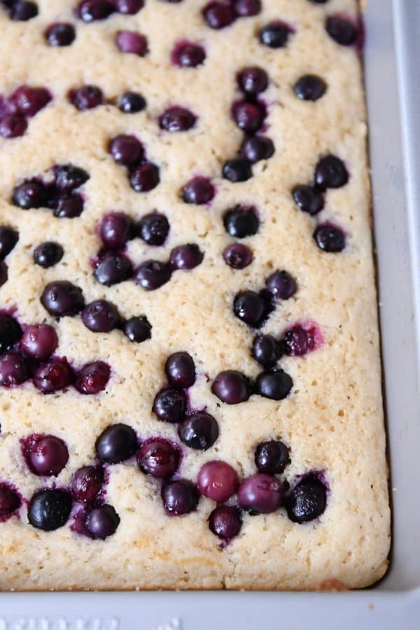 Baked pan of fluffy baked pancakes with blueberries on top.