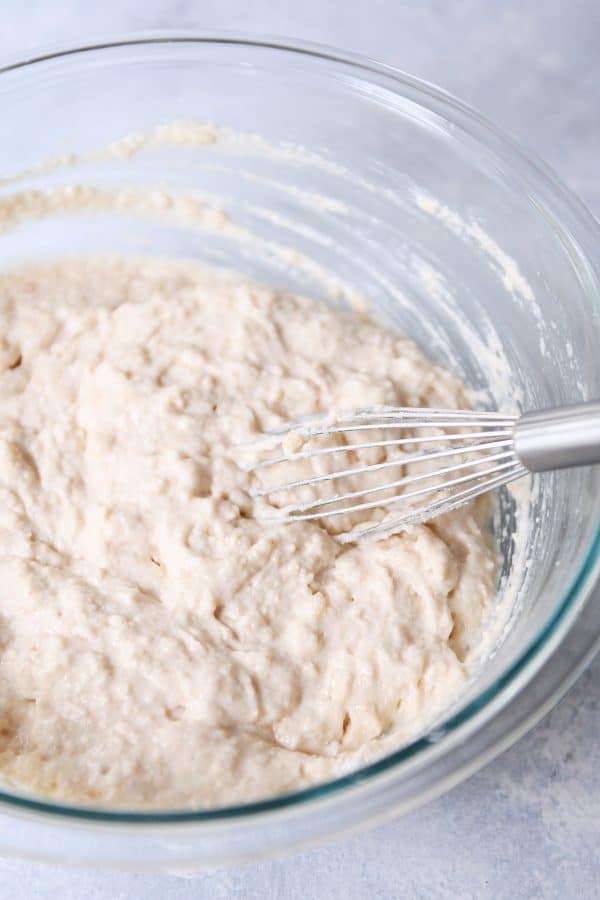 Whisking fluffy baked pancake batter in glass bowl.