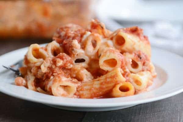 White plate with baked ziti and melted cheese.