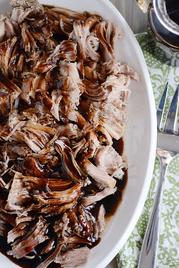 Top view of a plate full of shredded pork with balsamic glaze drizzled over the top