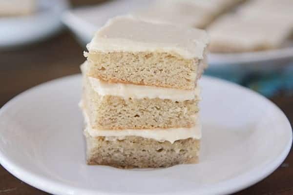 A stack of iced banana bars on a white plate. 