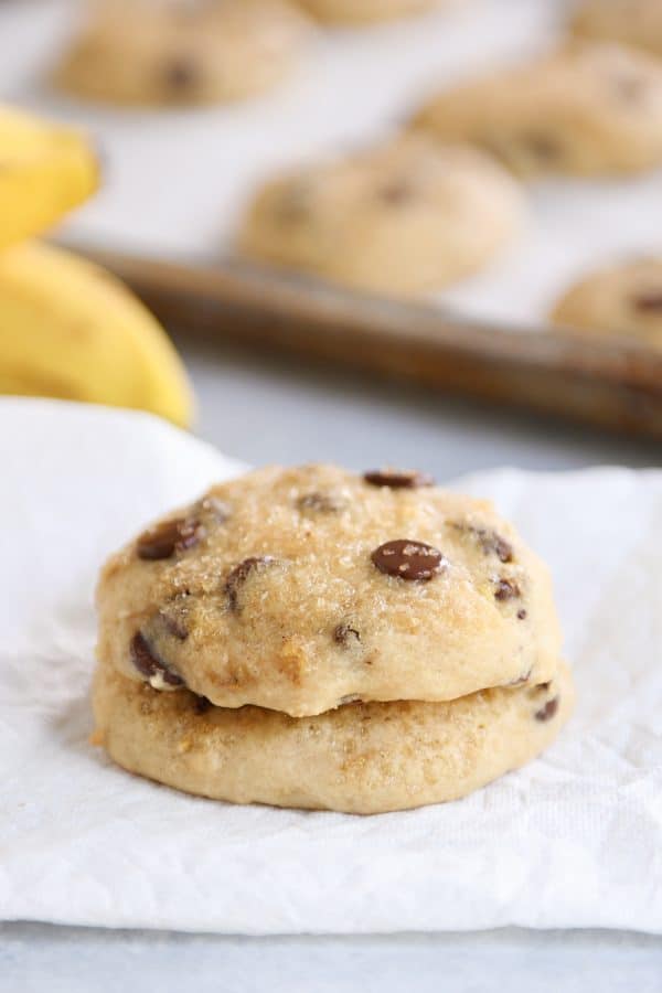 Stack of soft banana bread cookies on white napkin.