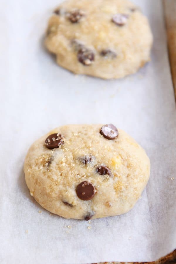 Two banana bread cookies on parchment lined baking sheet.