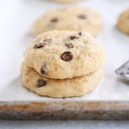 Stack of soft banana bread cookies on white napkin.