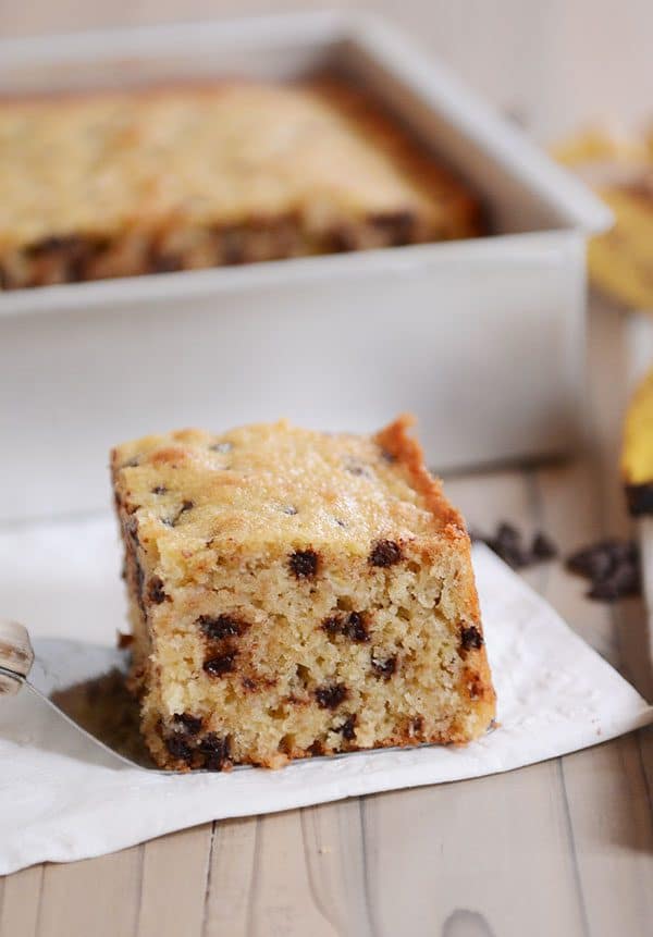 A square piece of banana chocolate chip cake sitting on a napkin.