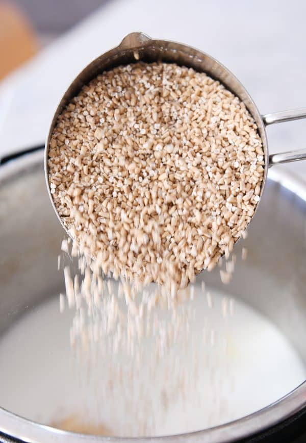 Steel cut oats being poured into an Instant Pot.