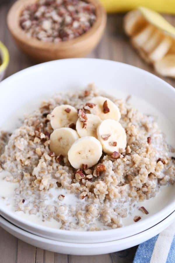 White bowl filled with Instant Pot banana bread steel cut oats with sliced bananas and milk.