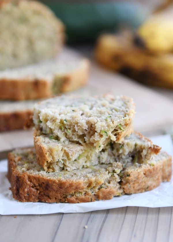 Two slices of zucchini banana bread with top slice broken in half.