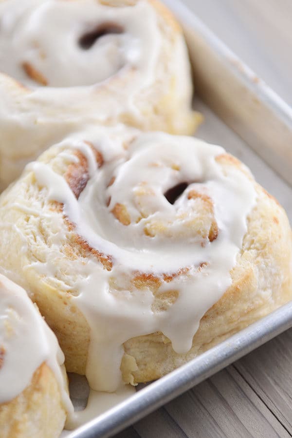 A cookie sheet full of frosted cinnamon rolls.