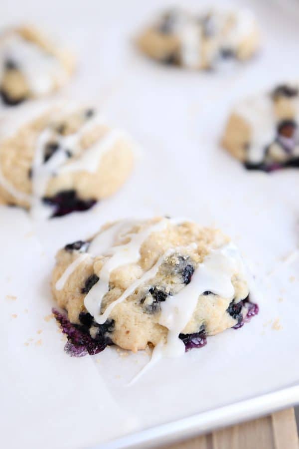 Glazed blueberry muffin cookie on parchment lined baking sheet.