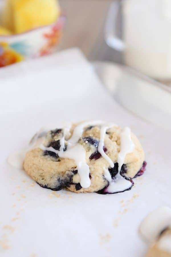 Glazed blueberry muffin cookie on parchment lined baking sheet.