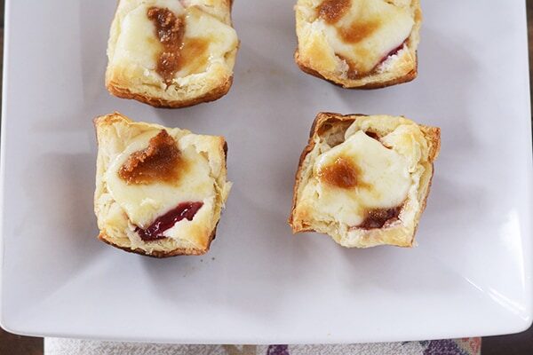 Top view of four puff pastry baked brie bites. 