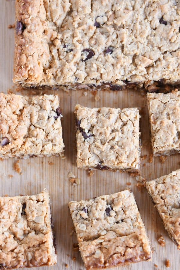 Top down shot of cut monster cookie bars on wood board.