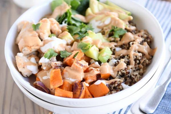 Assembled Buddha bowl recipe with peanut sauce in white bowl.