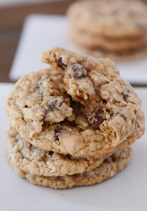 A stack of oatmeal butterscotch chocolate chip cookies with the top cookie split in half.