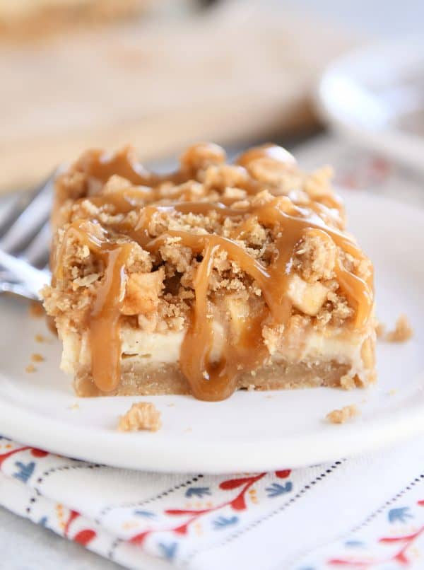 Caramel apple cheesecake bar on white plate.