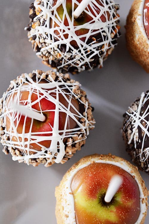 Top view of white chocolate drizzled and candy coated caramel apples. 