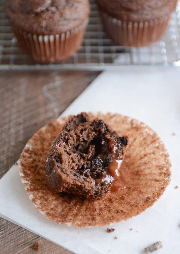Half of a double chocolate salted caramel muffin with caramel oozing out.