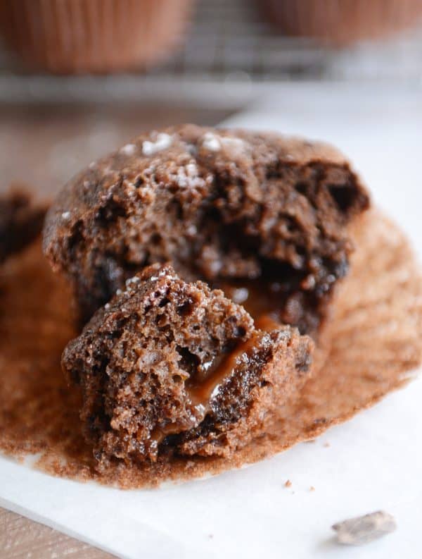 Half of a double chocolate salted caramel muffin with caramel oozing out.