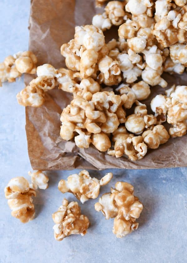 Soft and chewy caramel popcorn on brown paper bag.