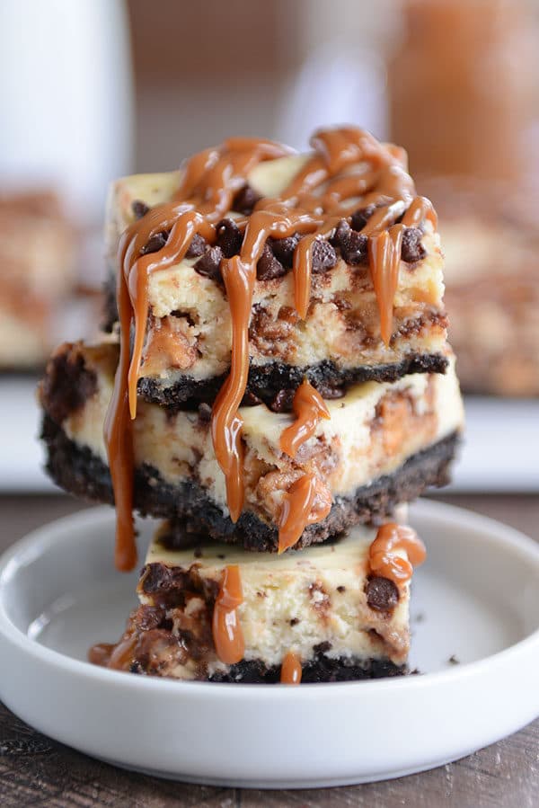 Stacked caramel cheesecake Oreo cheesecake bars in a white ramekin.