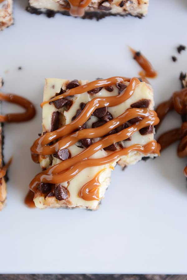 Top view of a caramel cheesecake chocolate chip bar with a bite taken out.