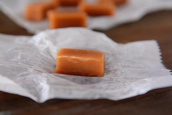 An unwrapped caramel on a small piece of parchment. 