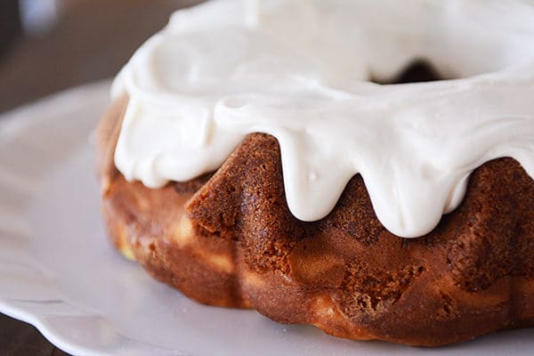 A carrot cake bundt cake with thick icing dripping down the top.