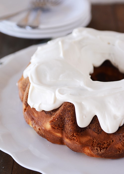 A carrot bundt cake with thick white icing on top. 