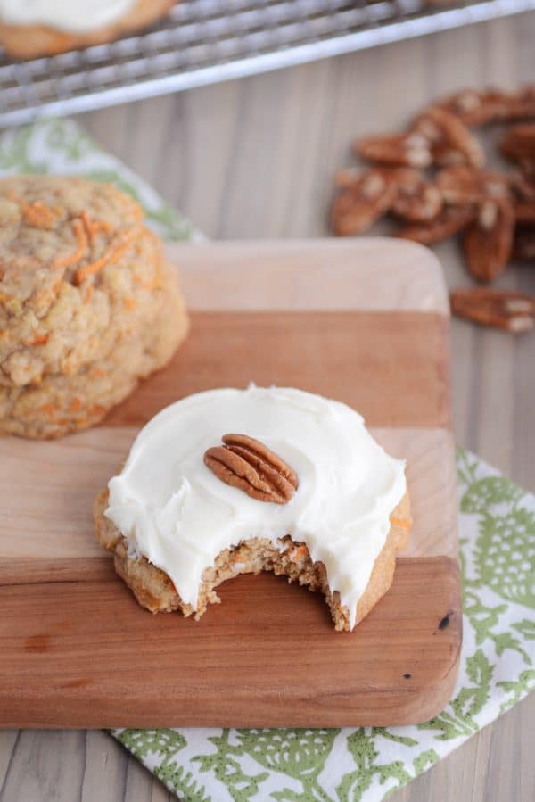 Frosted carrot cake cookie with a bite taken out.