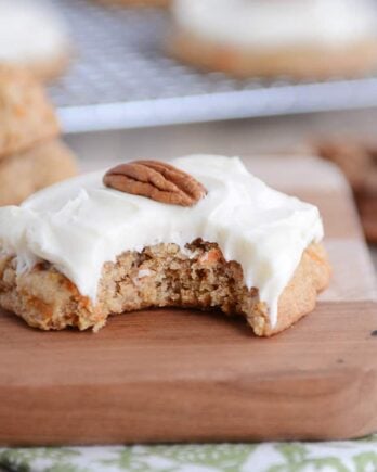 Frosted carrot cake cookie with a bite taken out.