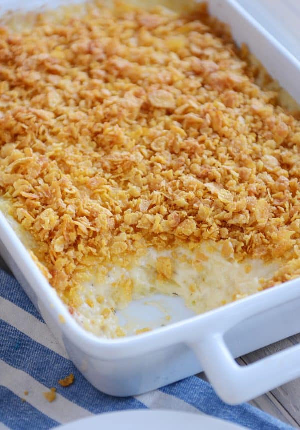 Pan of cheesy funeral potatoes with scoop taken out