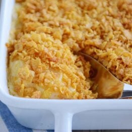 Scooping out a spoonful of cheesy funeral potatoes