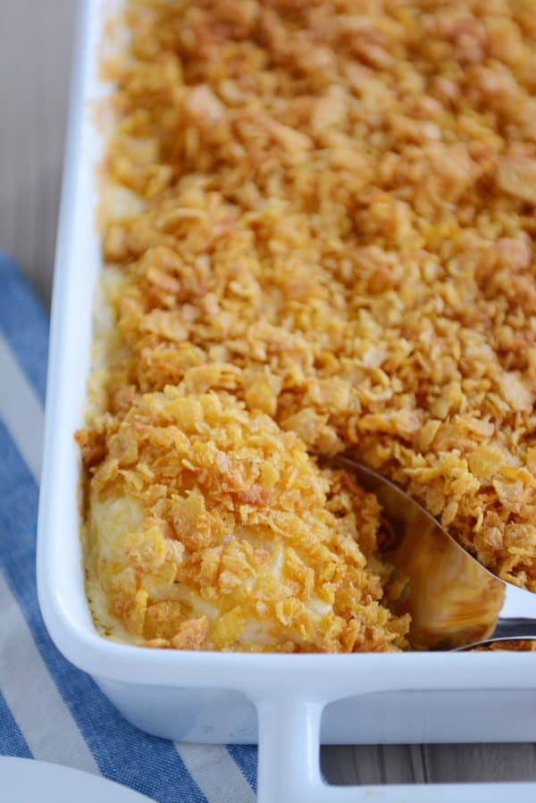 Scooping out a spoonful of cheesy funeral potatoes.