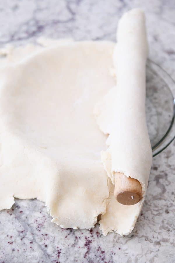 Rolling pie crust into 9-inch glass pie plate.