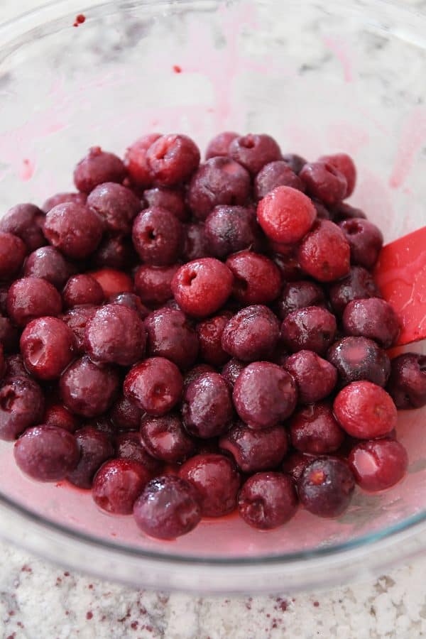 Homemade cherry pie filling in glass bowl.