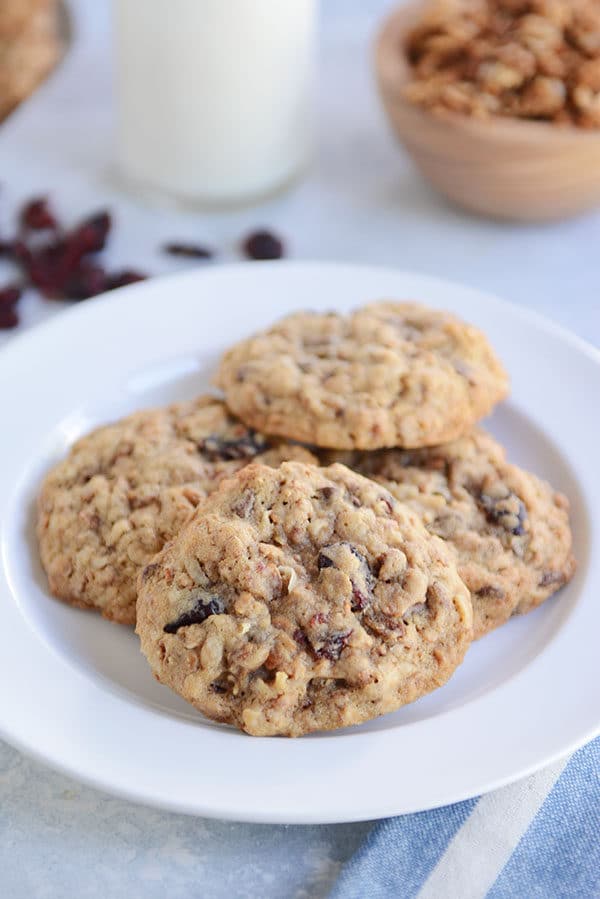 A white plate of four granola chocolate chip cookies.