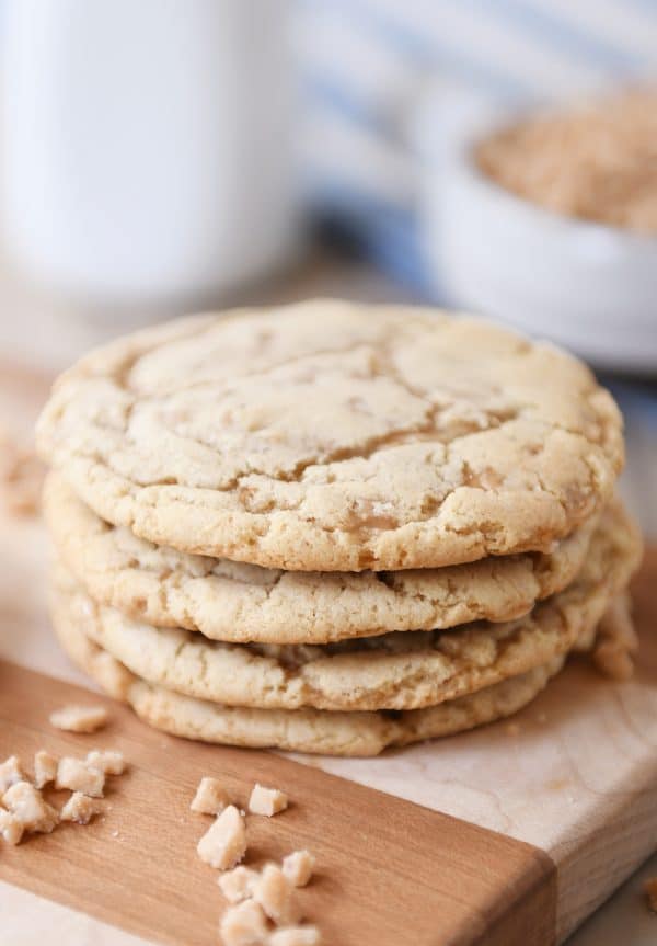 Stack of toffee cookies on wood cutting board.