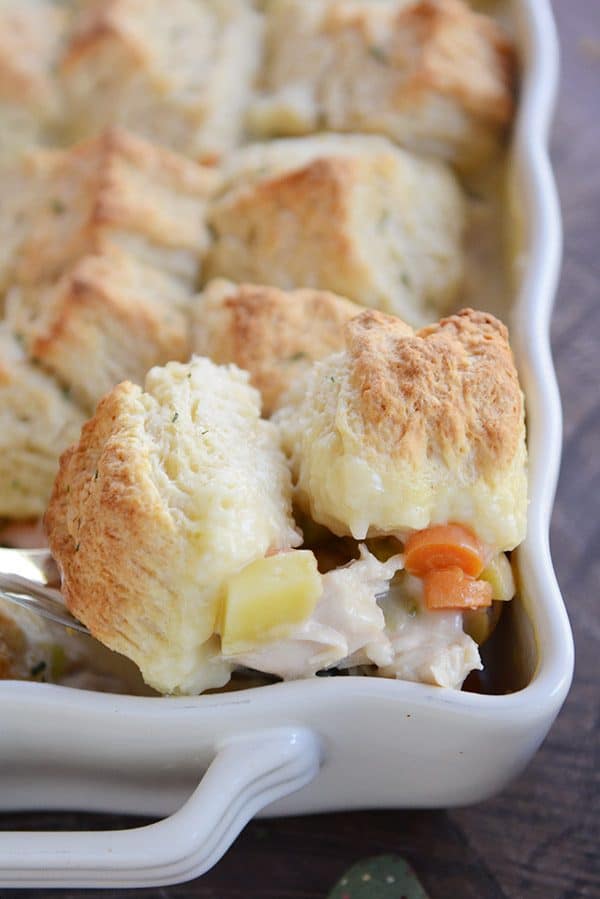 A white casserole dish of biscuit-topped chicken pot pie.