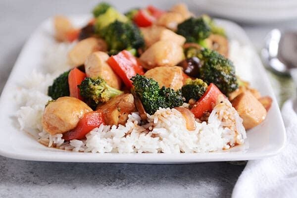 White rice covered with chicken and vegetable stir-fry. 