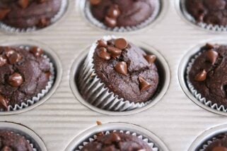 Double chocolate banana blender muffin propped on side in metal tin.