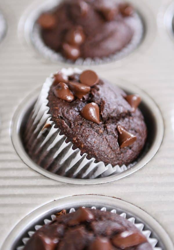 Double chocolate banana blender muffin propped on side in metal tin. 