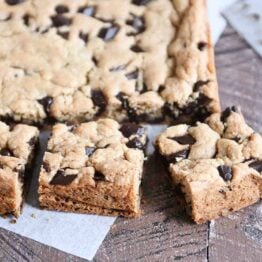 Slab of chocolate chip cookie bars cut into pieces.