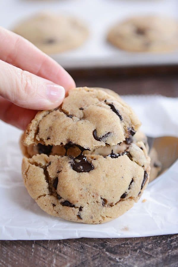 A thick and gooey chocolate chip cookie getting split in half. 