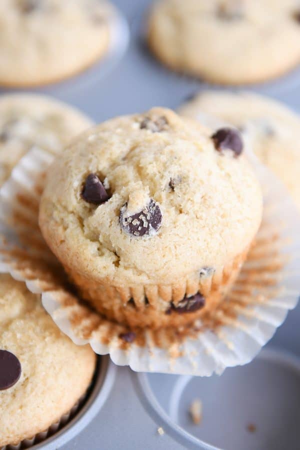 Easy one-bowl chocolate chip muffin unwrapped sitting on top of muffin tin.