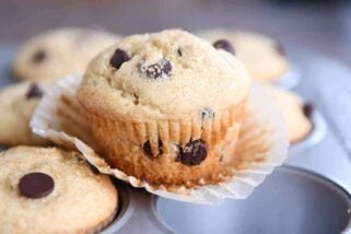 Easy one-bowl chocolate chip muffin unwrapped sitting on top of muffin tin.