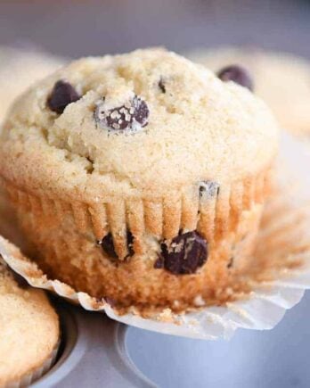 Easy one-bowl chocolate chip muffin unwrapped sitting on top of muffin tin.