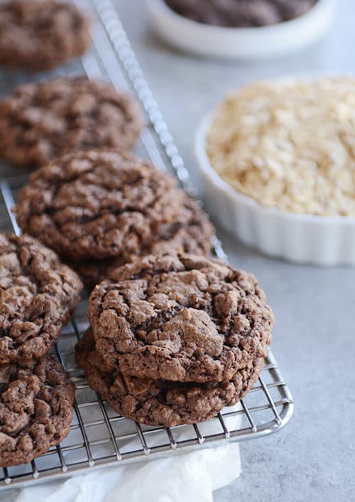 Chocolate oatmeal cookies stacked on a cooling rack.