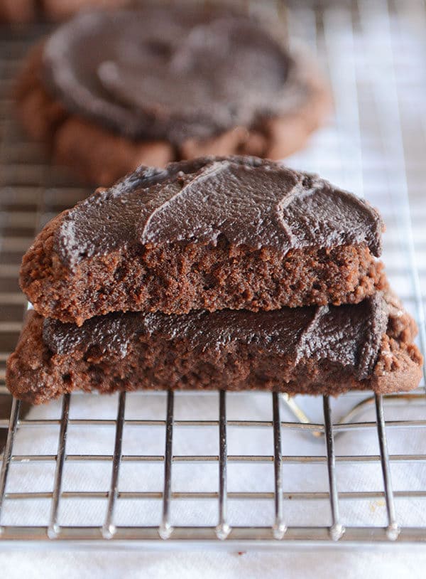 A chocolate frosted chocolate swig cookie split in half on a cooling rack.