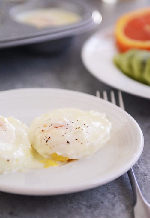 A white plate with a creamy cooked egg sprinkled with pepper. 